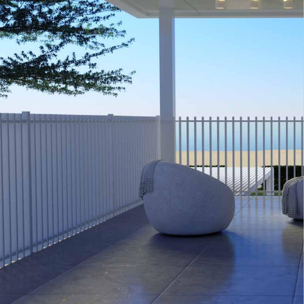 Modern outdoor balcony with white vertical railings a large rounded stone bench and a blue sea horizon in the distance